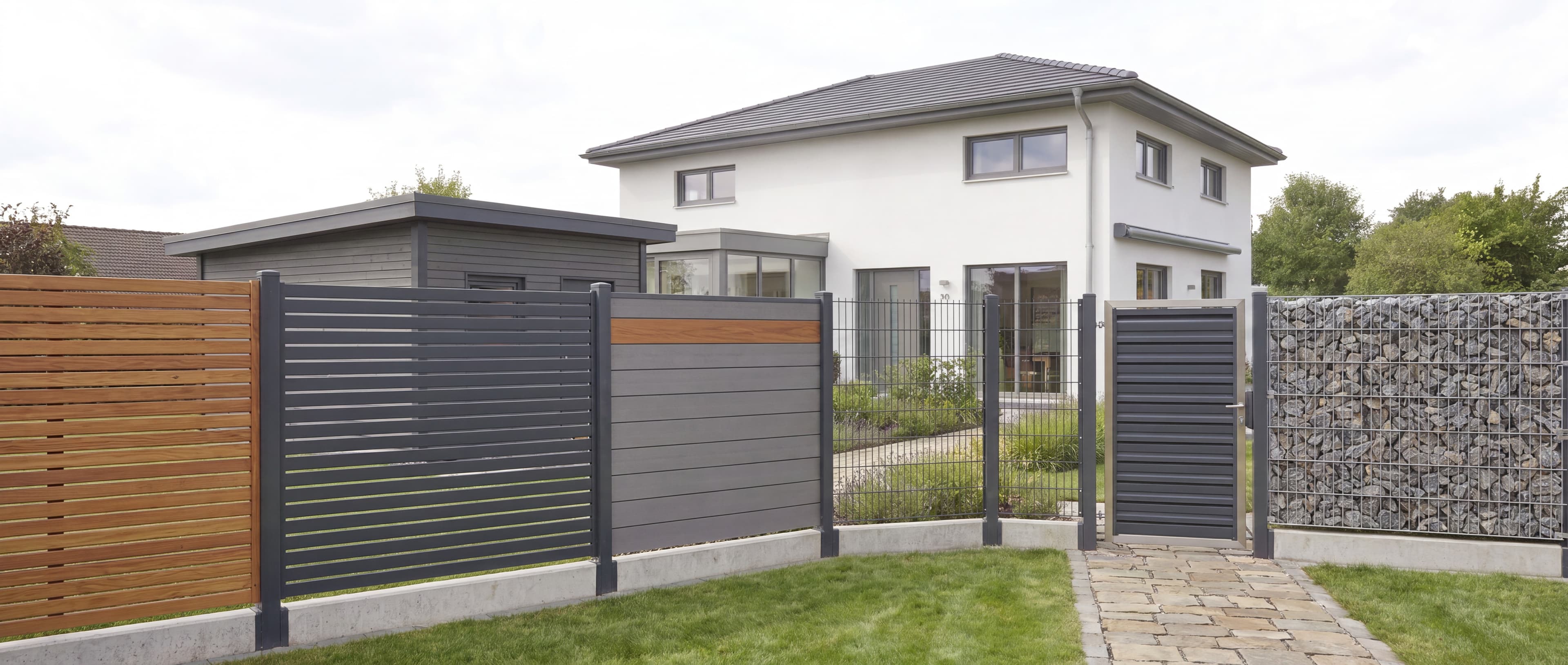 Gartenansicht mit fünf Zaunarten nebeneinander: Holzzaun, Rhombuszaun, WPC-Zaun, Doppelstabmattenzaun und Gabionenzaun